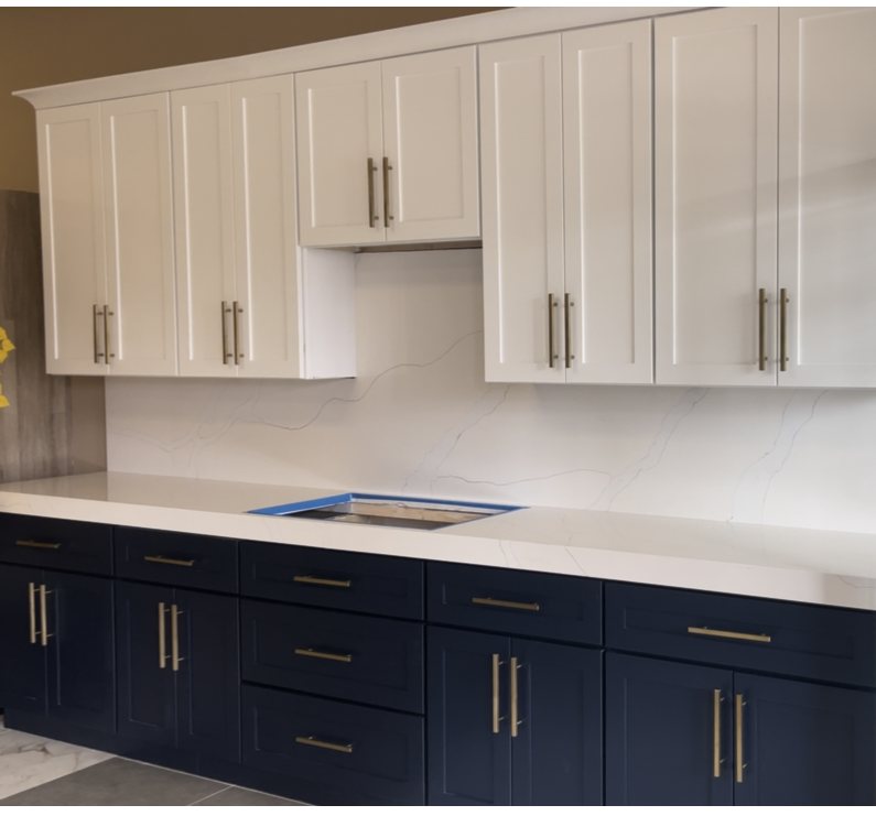 Navy and white two-tone kitchen with a full-height quartz backsplash