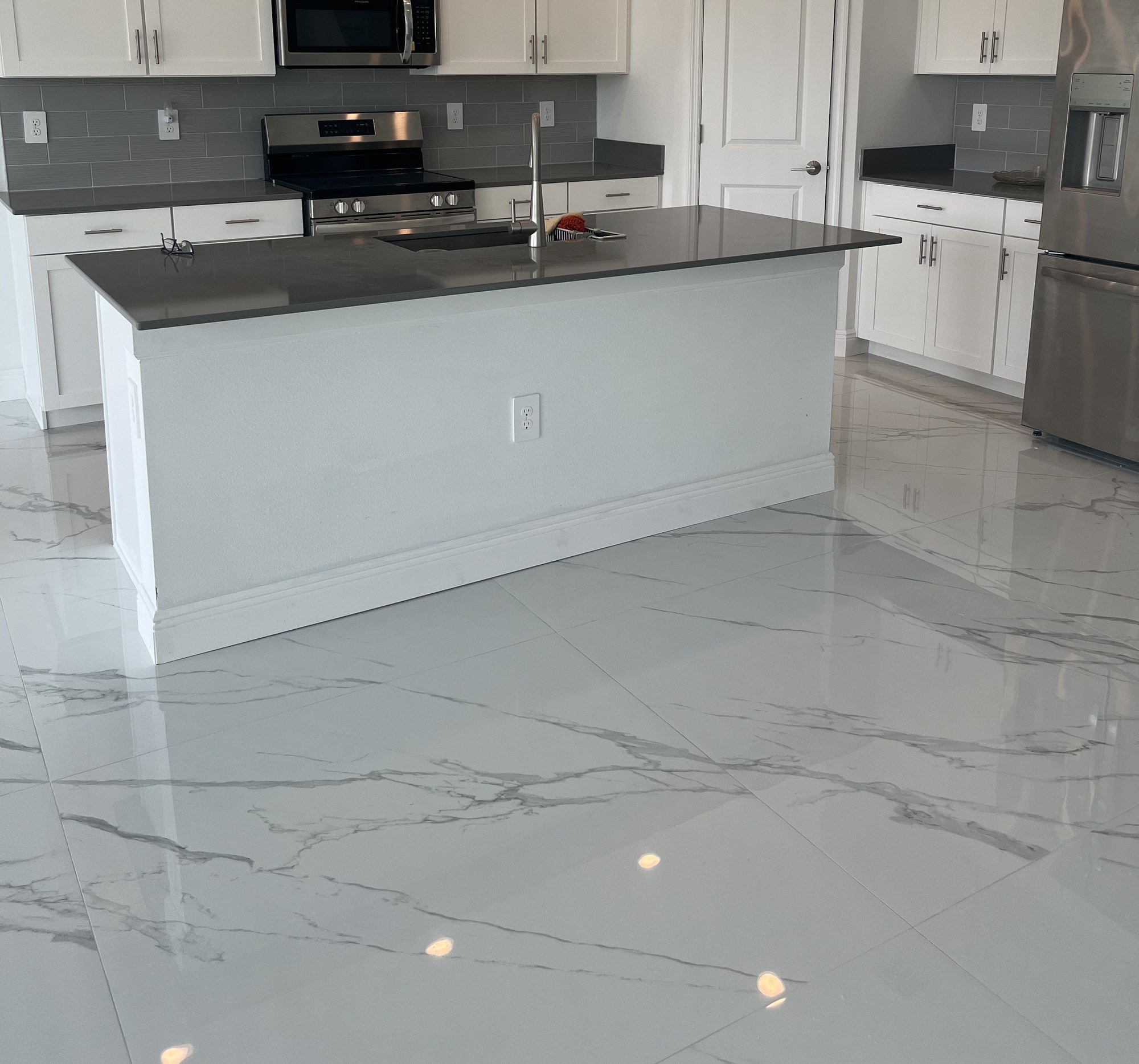 High-gloss porcelain tile floor with marble veining, wall to wall