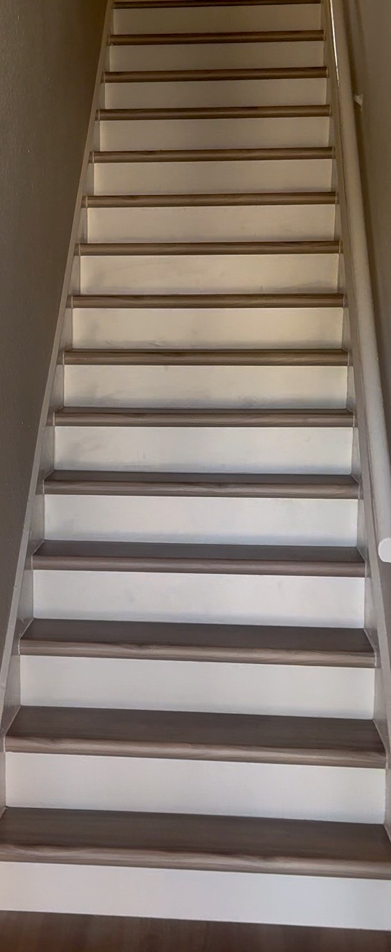 Vinyl plank installed on a staircase with white risers