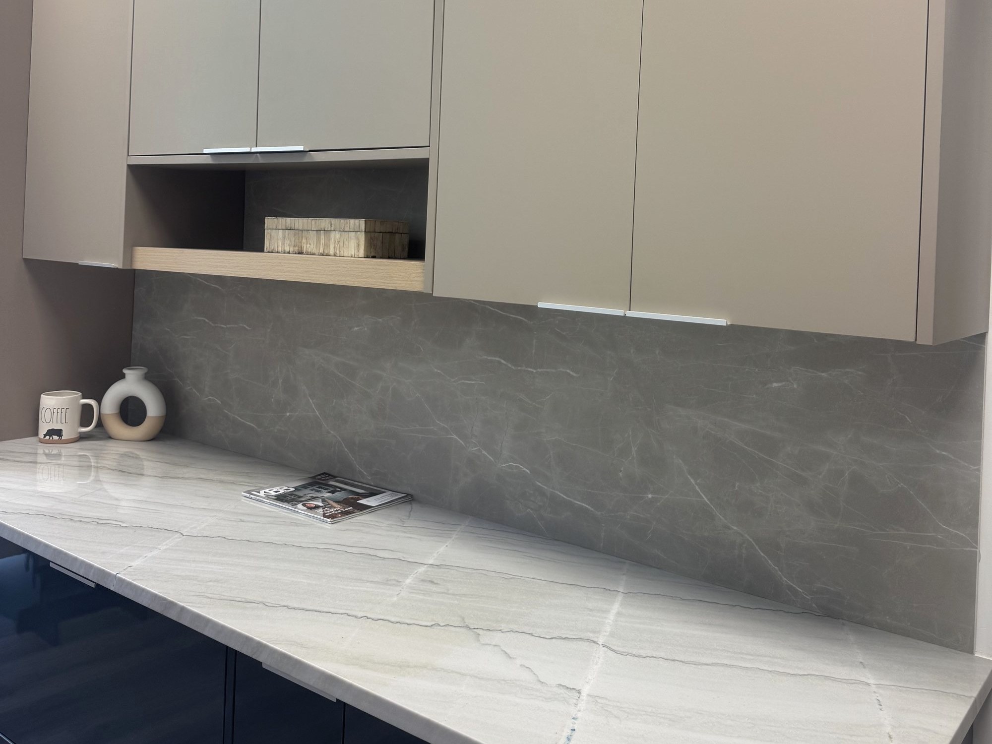 Showroom display: sand cabinets with glossy navy base, quartzite counter and gray porcelain backsplash, Kissimmee